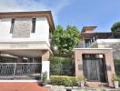 Elegant two-story house with stone accents and a secure entrance gate