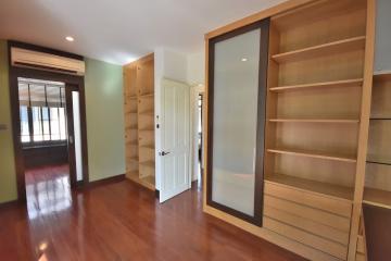 Spacious bedroom with large wooden closet and gleaming hardwood floors