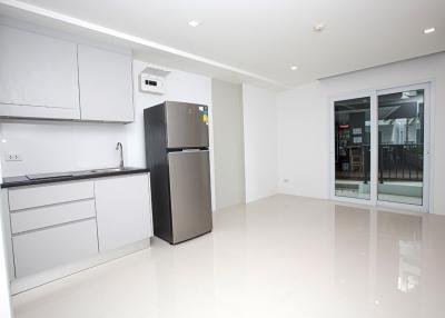 Spacious and modern kitchen interior with stainless steel refrigerator