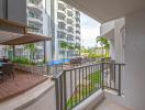 Spacious balcony overlooking the communal pool and lounge area in a modern apartment complex