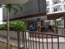 Covered outdoor patio area near residential building with seating and plant decorations