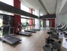 Modern gym with cardio equipment and large windows