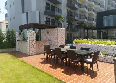 Modern outdoor dining space adjacent to pool area with comfortable seating and stylish stone wall design