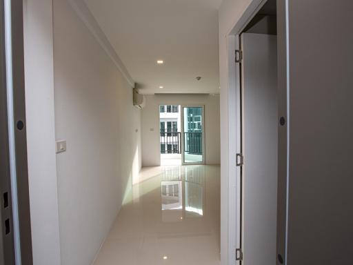 Spacious and well-lit hallway leading to a balcony in a modern apartment