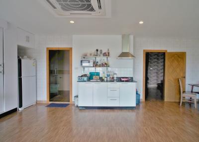Spacious modern kitchen with stainless steel appliances and wooden flooring