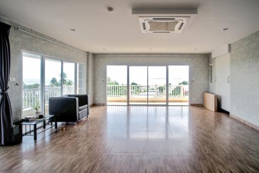 Spacious living room with large windows and hardwood floors