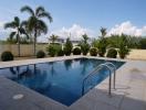 Spacious outdoor swimming pool with tropical landscaping