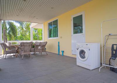 Spacious covered patio with outdoor furniture and laundry appliances