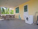 Spacious covered patio with outdoor furniture and laundry appliances