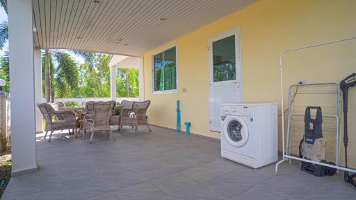 Spacious covered patio with outdoor furniture and laundry appliances