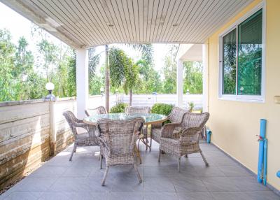 Spacious covered patio area with outdoor furniture and garden view