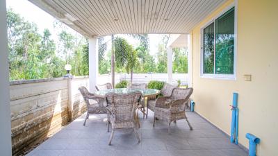 Spacious covered patio area with outdoor furniture and garden view