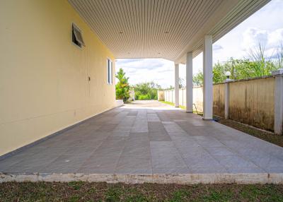 Spacious tiled patio with a covered area and open walls leading to the backyard