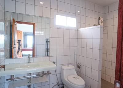 Modern bathroom with tiled walls, glass shower, and large mirror