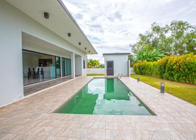 Spacious backyard with a swimming pool and patio area adjacent to the house