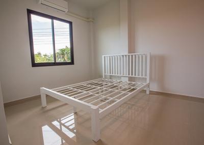 Bright and minimalistic bedroom with white bed frame