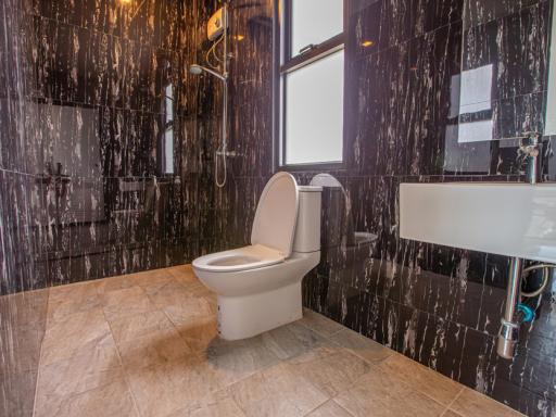 Modern bathroom with dark marble walls and floor