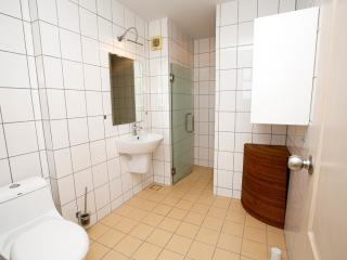 Bright and clean bathroom with tiled walls and a glass shower enclosure