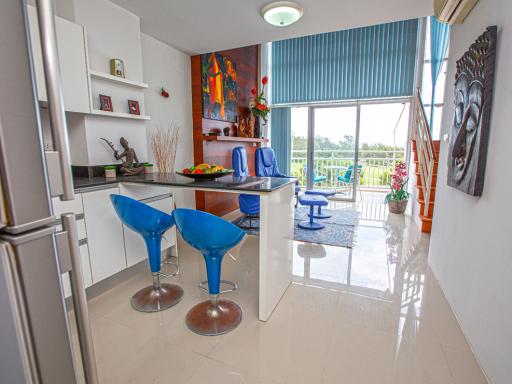 Modern kitchen with high bar stools and staircase