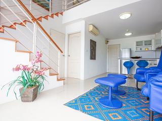 Bright and airy living room with staircase and open kitchen area