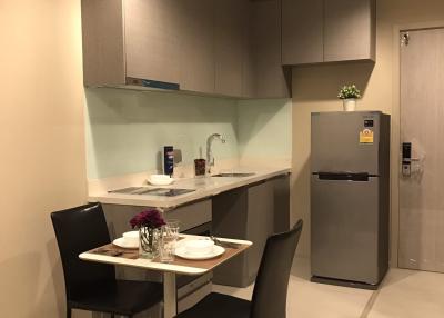 Modern kitchen with stainless steel appliances and a small dining area