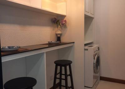 Compact kitchen area with modern appliances and bar seating