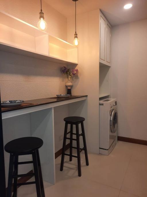 Compact kitchen area with modern appliances and bar seating