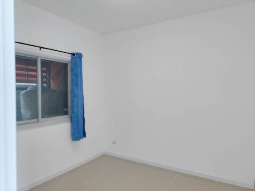 Empty bedroom with a large window and blue curtains