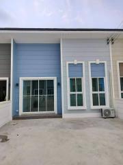 Modern blue house exterior with a concrete patio area
