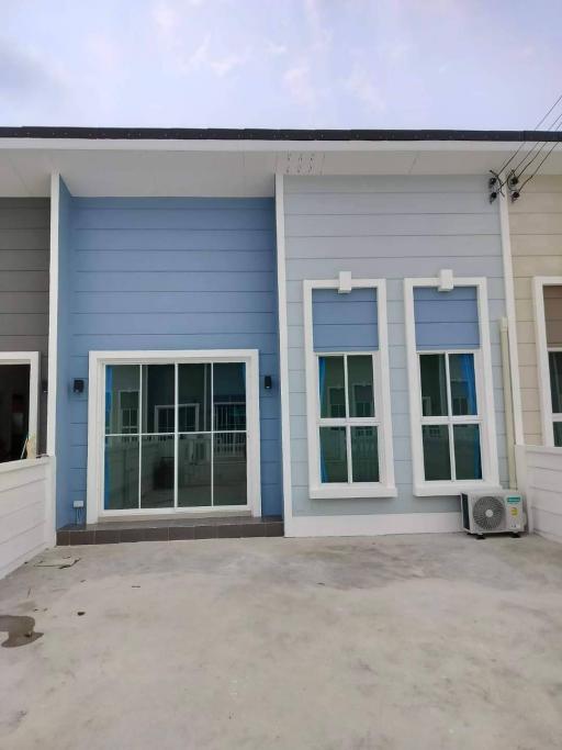 Modern blue house exterior with a concrete patio area