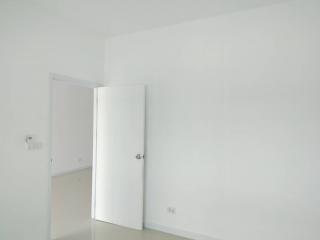 Minimalist white room with an upright fridge