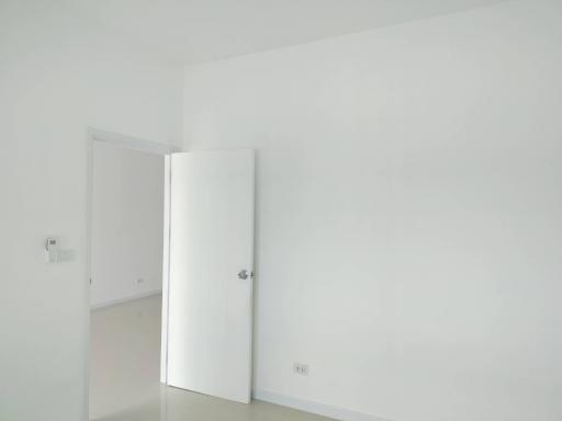 Minimalist white room with an upright fridge