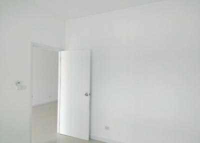 Minimalist white room with an upright fridge