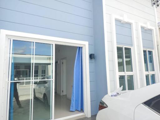 Modern home exterior with double glass doors and a blue facade