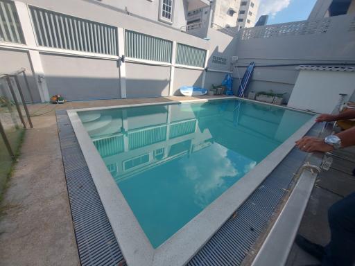 Private outdoor swimming pool area with surrounding buildings