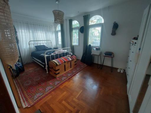 Cozy bedroom with natural light and hardwood flooring