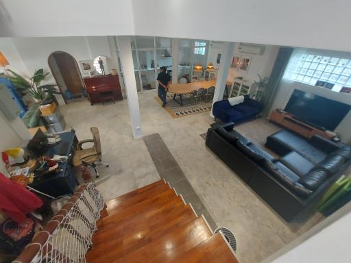 Spacious living room with high ceiling, natural light, and an open-floor layout