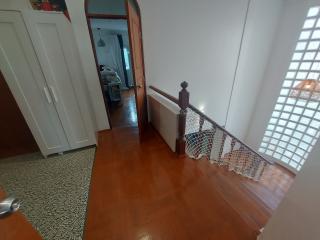 Spacious hallway with tiled flooring and safety netting along the stairwell