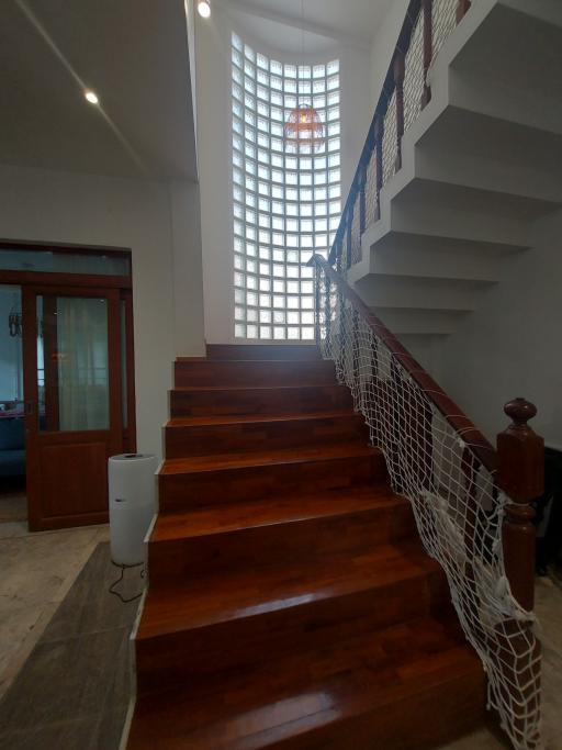 Elegant wooden staircase with natural light filtering through large window