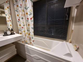 Spacious bathroom with tub and modern fixtures