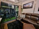 Cozy living room with leather sofa and glass sliding door leading to balcony