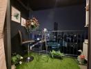 Cozy balcony at night with artificial turf and city view