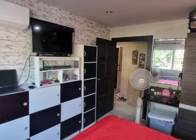 Modern bedroom interior with red accents and entertainment unit