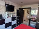 Modern bedroom interior with red accents and entertainment unit