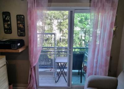 Cozy living room with balcony access showcasing greenery outside