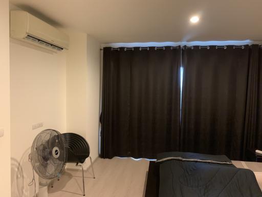 Contemporary bedroom with dark curtains and air conditioning