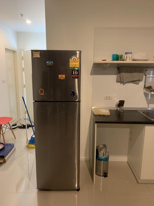 Compact kitchen with stainless steel refrigerator and modern amenities