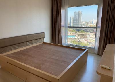 Spacious bedroom with large window overlooking the city