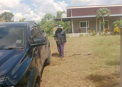 Man standing outside a house with a car parked in front