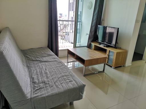 Modern living room interior with sofa, TV, and balcony access